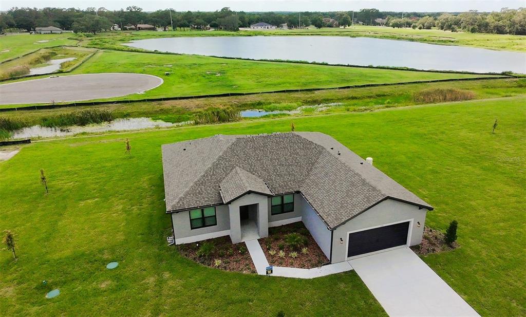 a aerial view of a house with big yard and large trees
