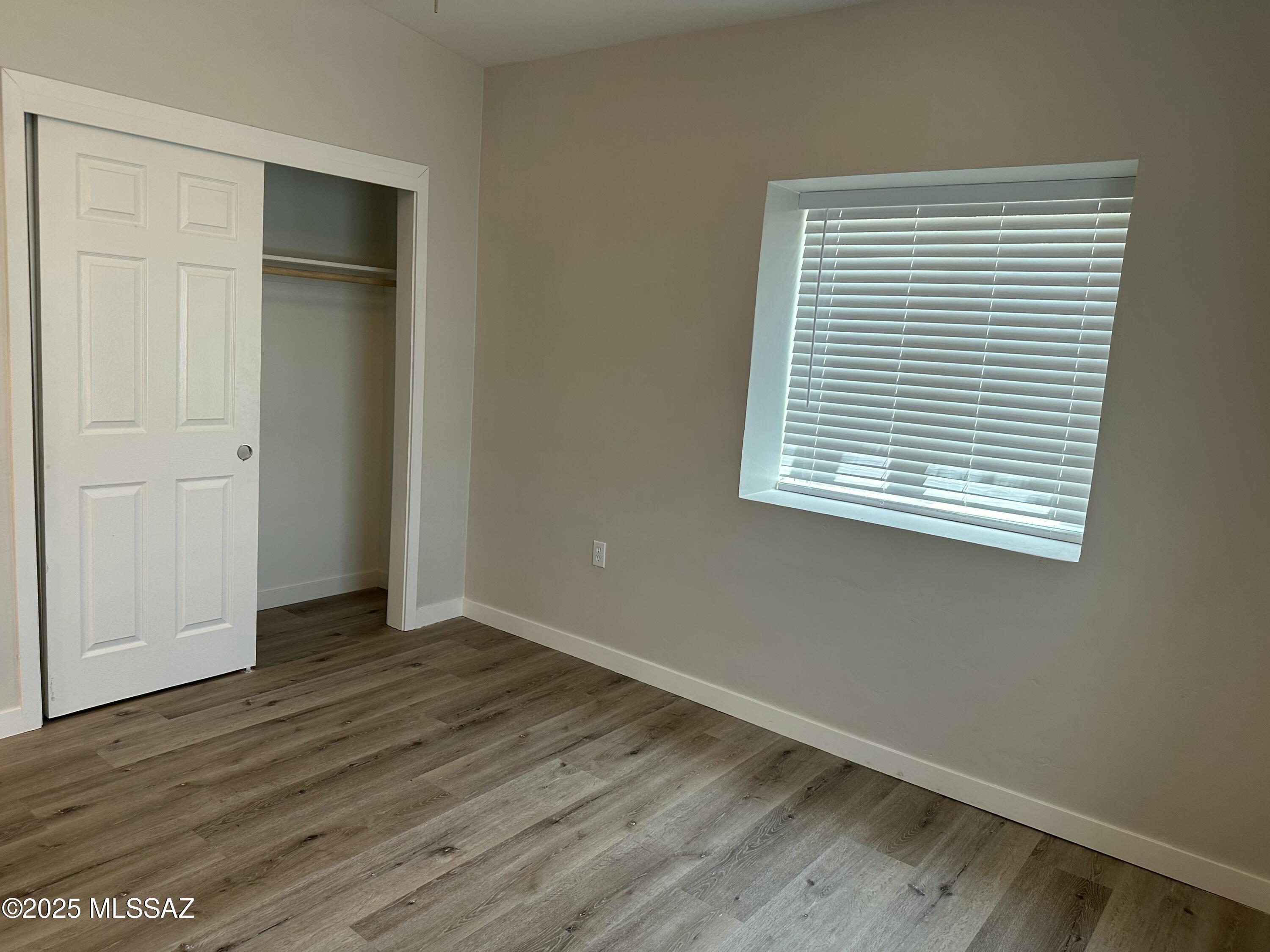 645 East Mabel Street Tucson, AZ 85705 - Photo 14 of 22 an empty room with wooden floor closet and windows
