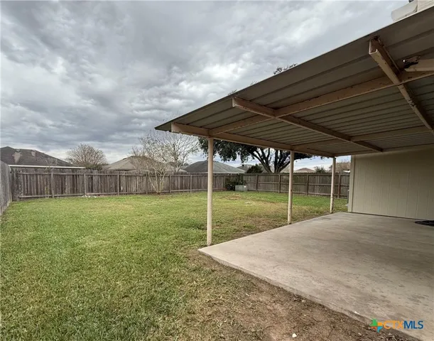 a view of a backyard with wooden fence