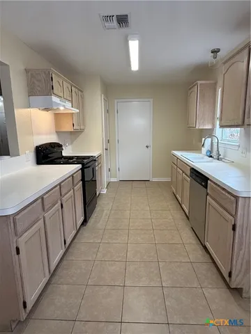 a kitchen with a sink stove and cabinets