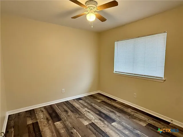 a view of a room with wooden floor and fan