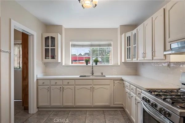 a kitchen with white cabinets and appliances