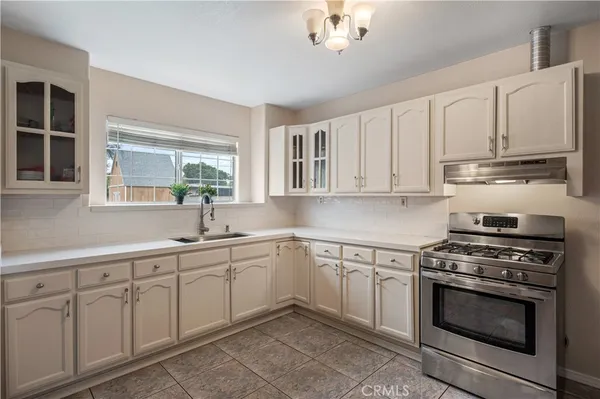 a kitchen with cabinets appliances a sink and a window