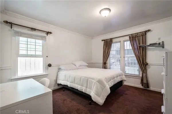 a bedroom with a bed and a large window