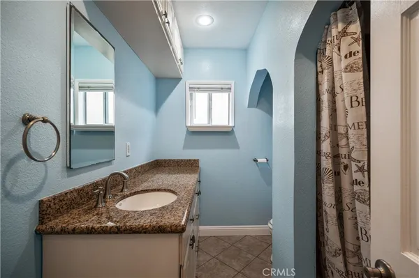 a bathroom with a granite countertop sink and a mirror