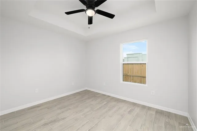 an empty room with a window and a ceiling fan