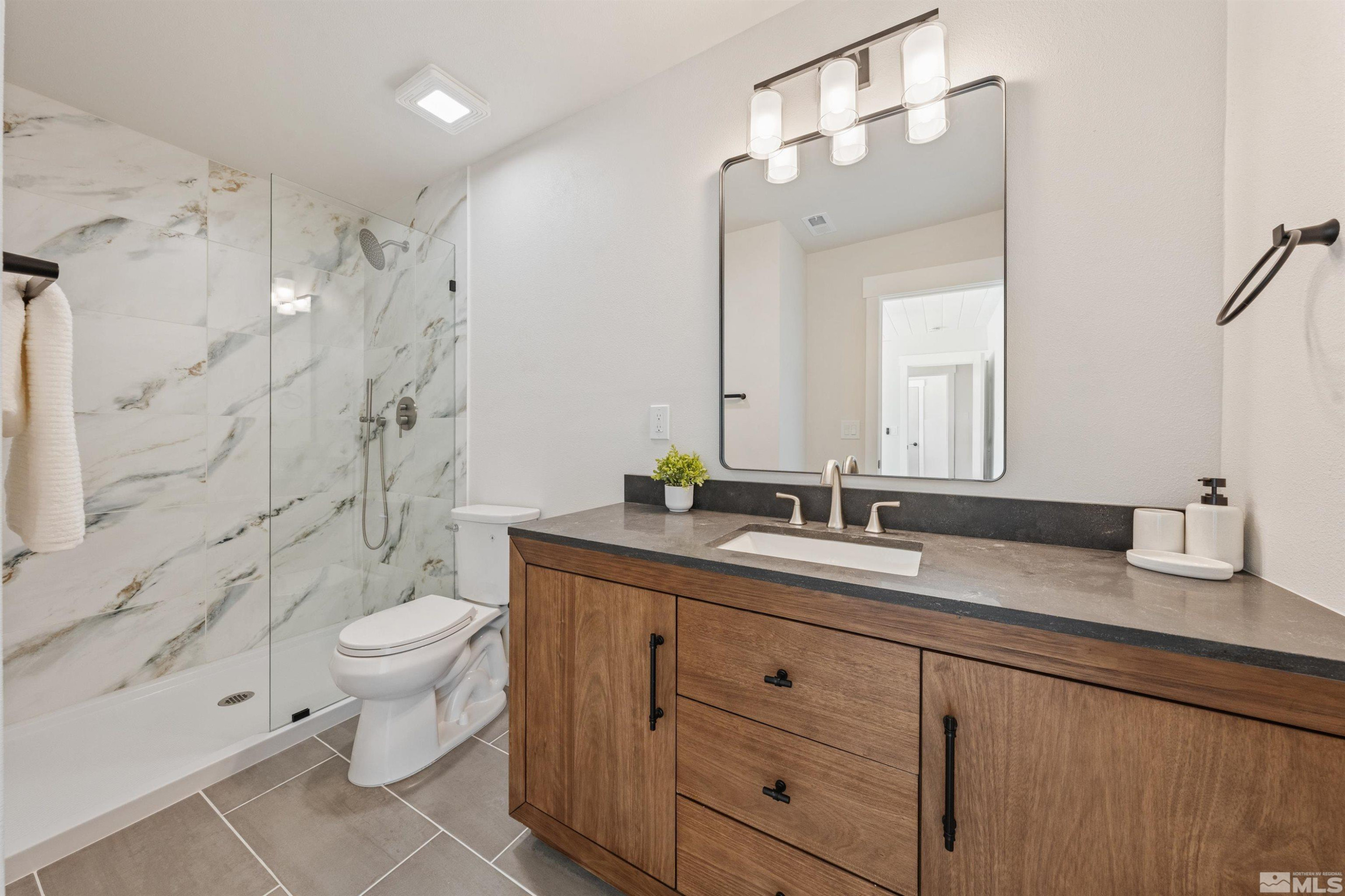 983 Melba Drive Reno, NV 89503 - Photo 20 of 39 a bathroom with a granite countertop sink toilet mirror and shower