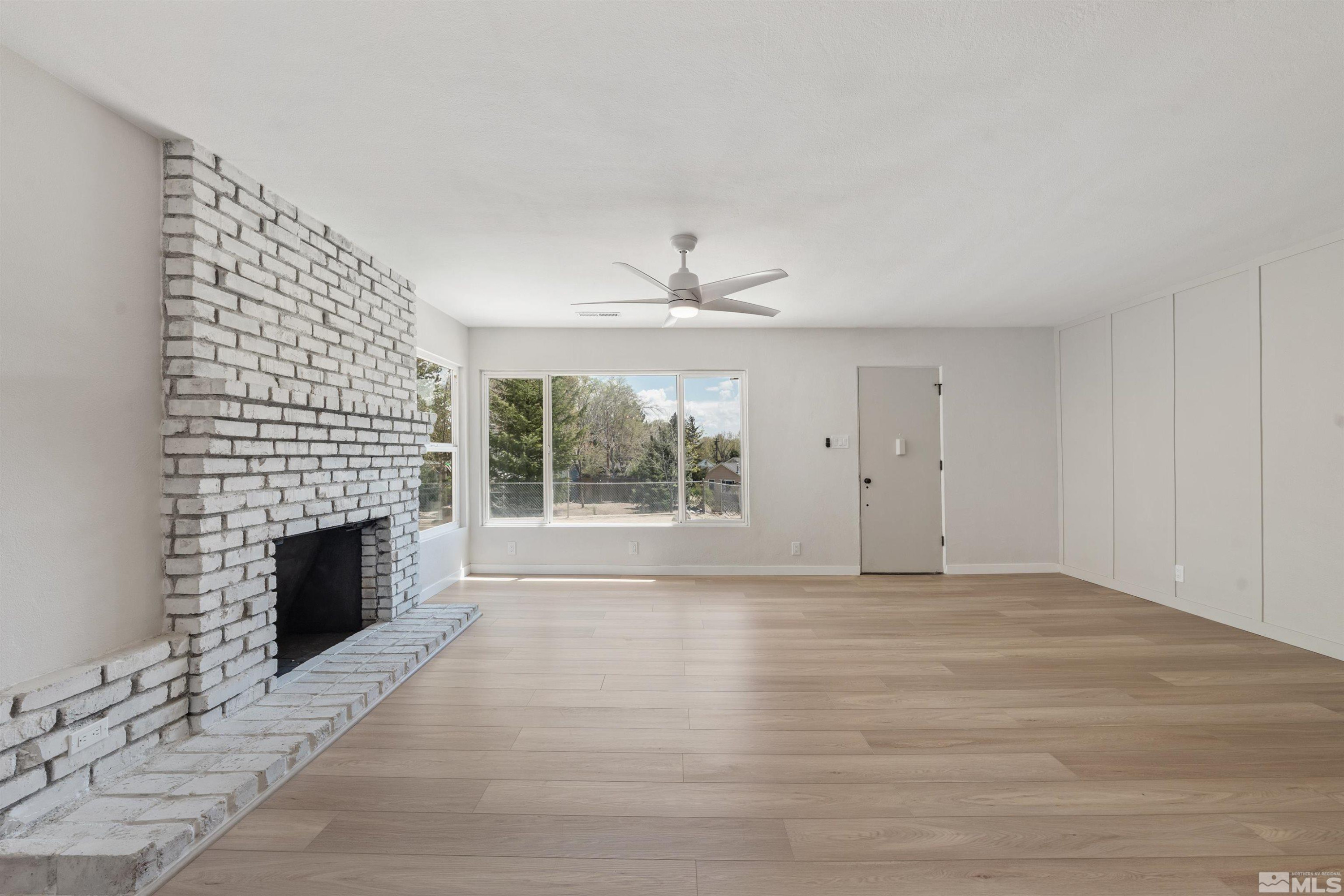 983 Melba Drive Reno, NV 89503 - Photo 4 of 39 a view of empty room with fireplace and windows