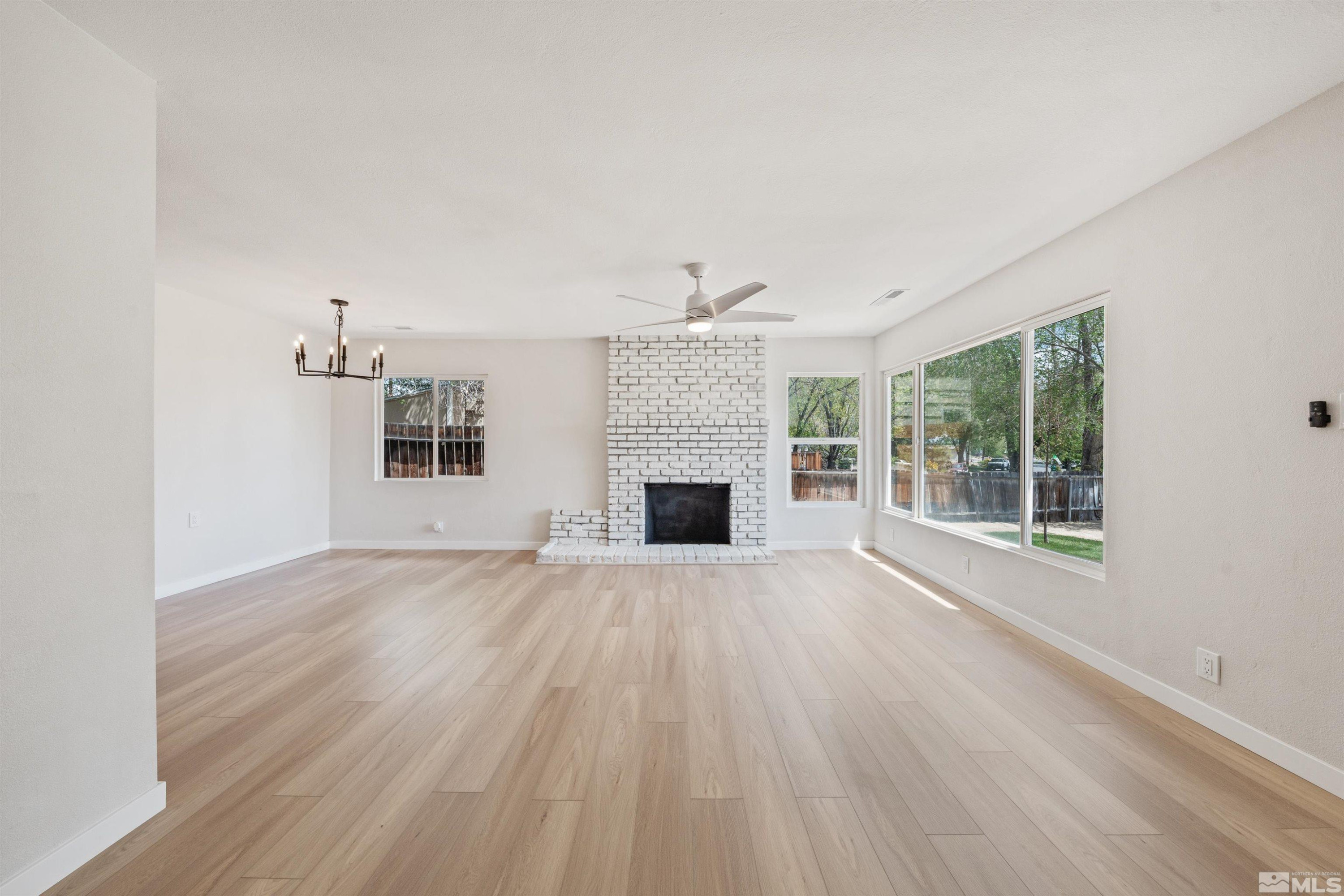 983 Melba Drive Reno, NV 89503 - Photo 7 of 39 wooden floor fireplace and windows in an empty room