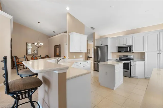 a kitchen with a sink stainless steel appliances and white cabinets