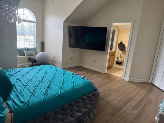 a living room with a bed furniture and a flat screen tv