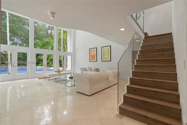 a living room with furniture and large windows