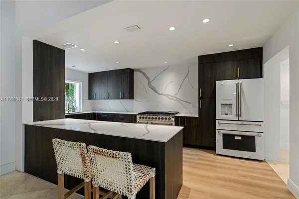 a kitchen with a table chairs refrigerator and microwave