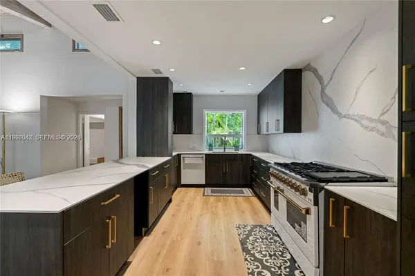 a large kitchen with granite countertop a stove and a sink