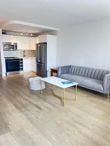 a living room with furniture and a kitchen