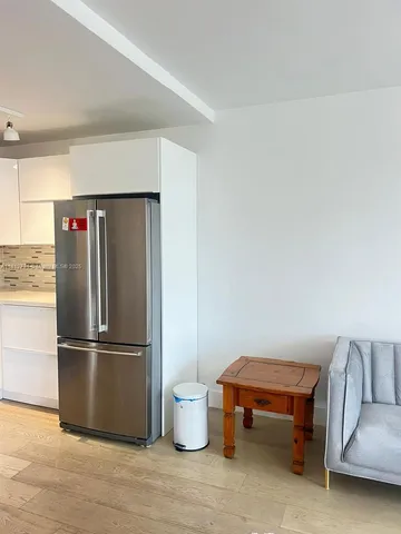 a room with a chair and a refrigerator