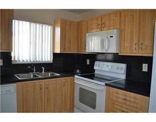 2801 North 34th Avenue Hollywood, FL 33021 - Photo 6 of 9 a kitchen with granite countertop a sink a stove and wooden cabinets