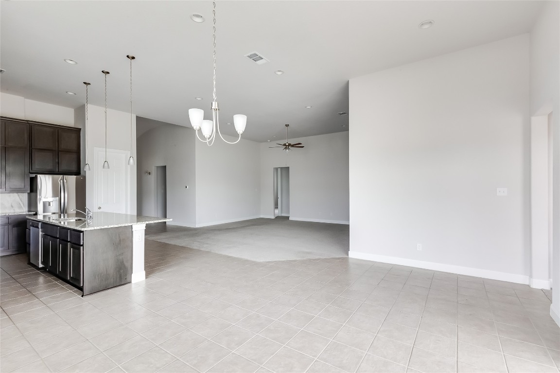 1948 Equine Road Leander, TX 78641 - Photo 17 of 36 Kitchen with dark brown cabinets, pendant lighting, ceiling fan, an island with sink, and appliances with stainless steel finishes