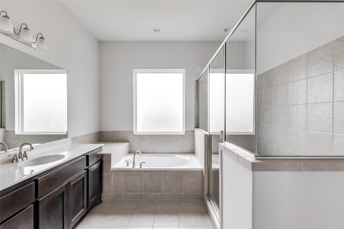 1948 Equine Road Leander, TX 78641 - Photo 22 of 36 Full bath with a garden tub, vanity, a shower stall, and light tile patterned flooring