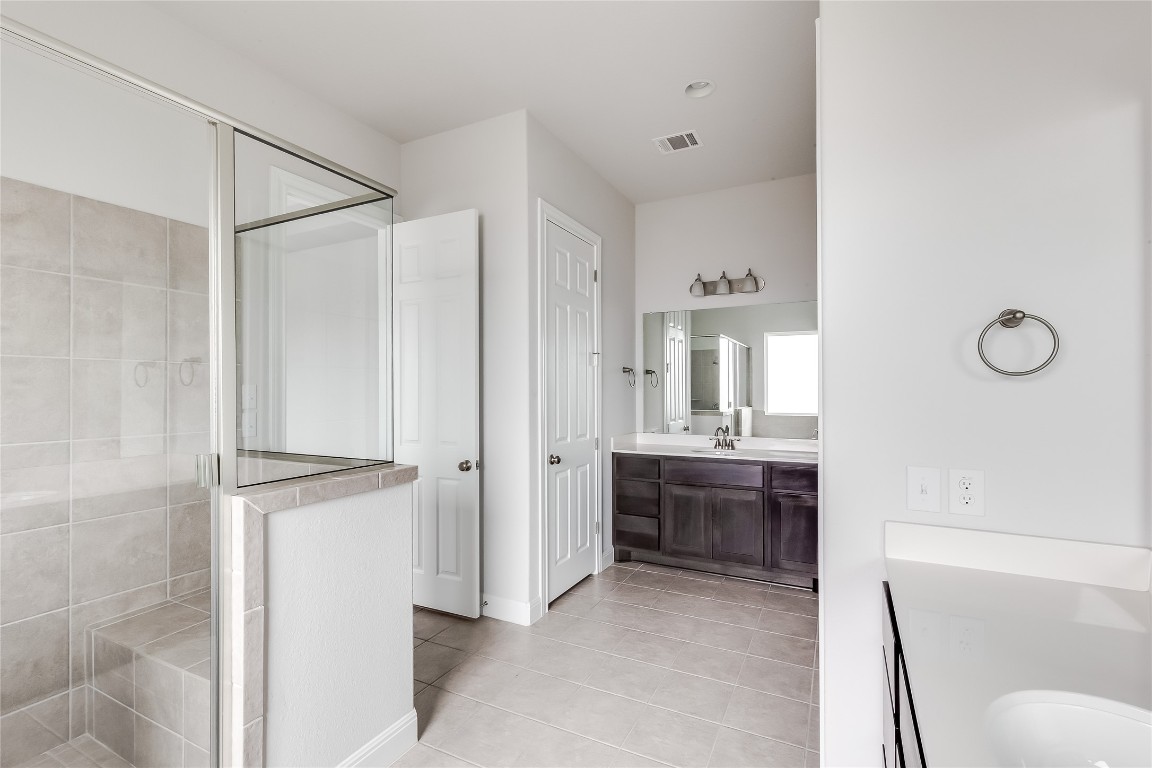 1948 Equine Road Leander, TX 78641 - Photo 23 of 36 Bathroom featuring vanity, a shower stall, and light tile patterned flooring