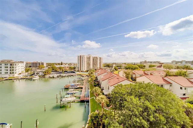 an aerial view of ocean and residential houses with outdoor space