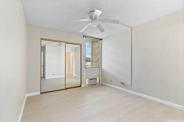 an empty room with fan and windows
