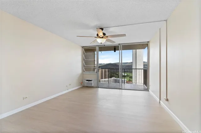 an empty room with a ceiling fan and a large window