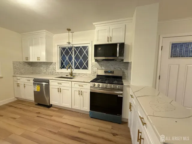 a kitchen with stainless steel appliances granite countertop a stove and a sink