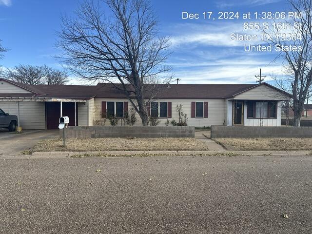 a front view of a house with a dirt yard and a large tree