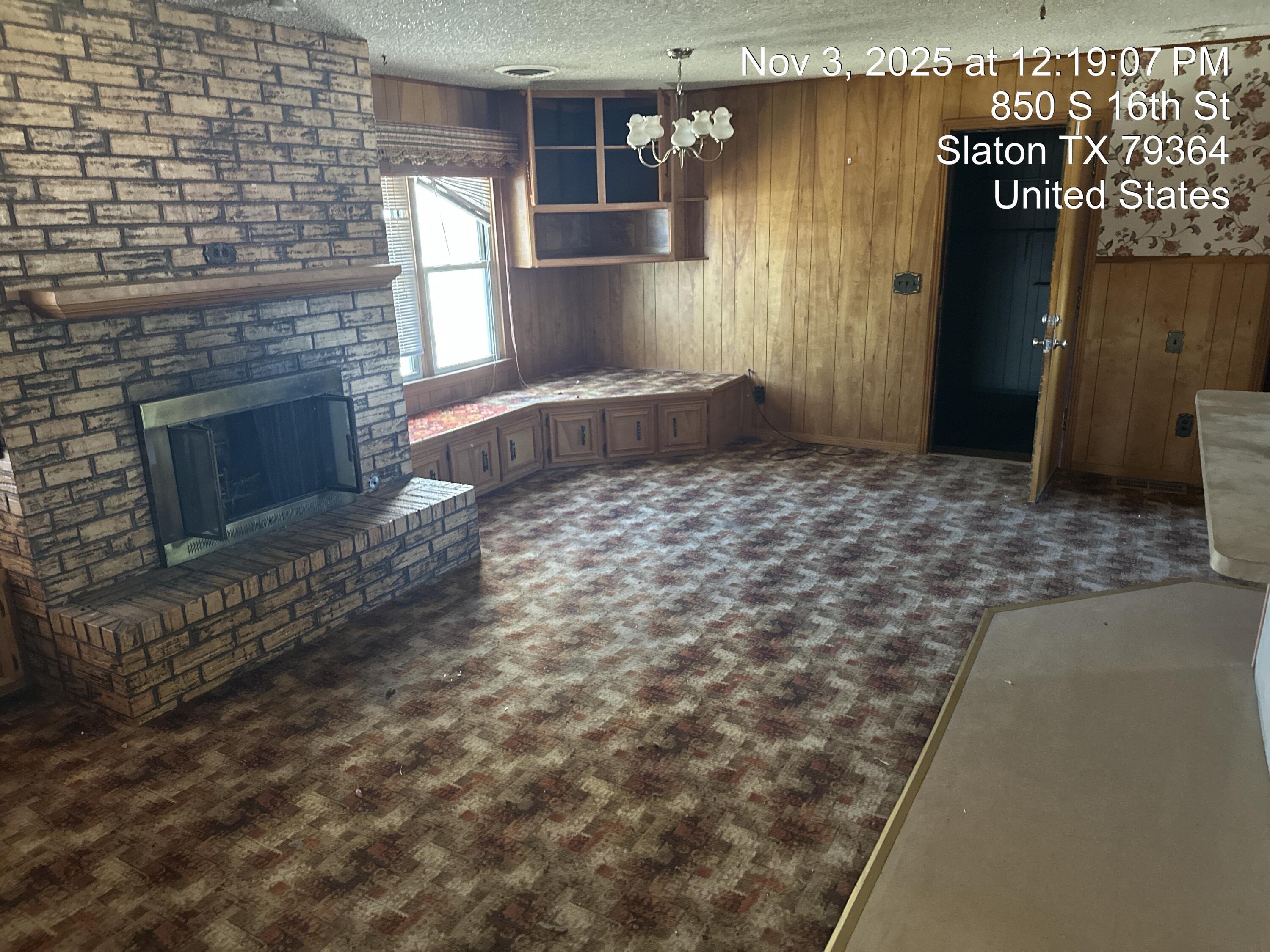 850 South 16th Street Slaton, TX 79364 - Photo 8 of 17 a view of a livingroom with wooden floor and a fireplace