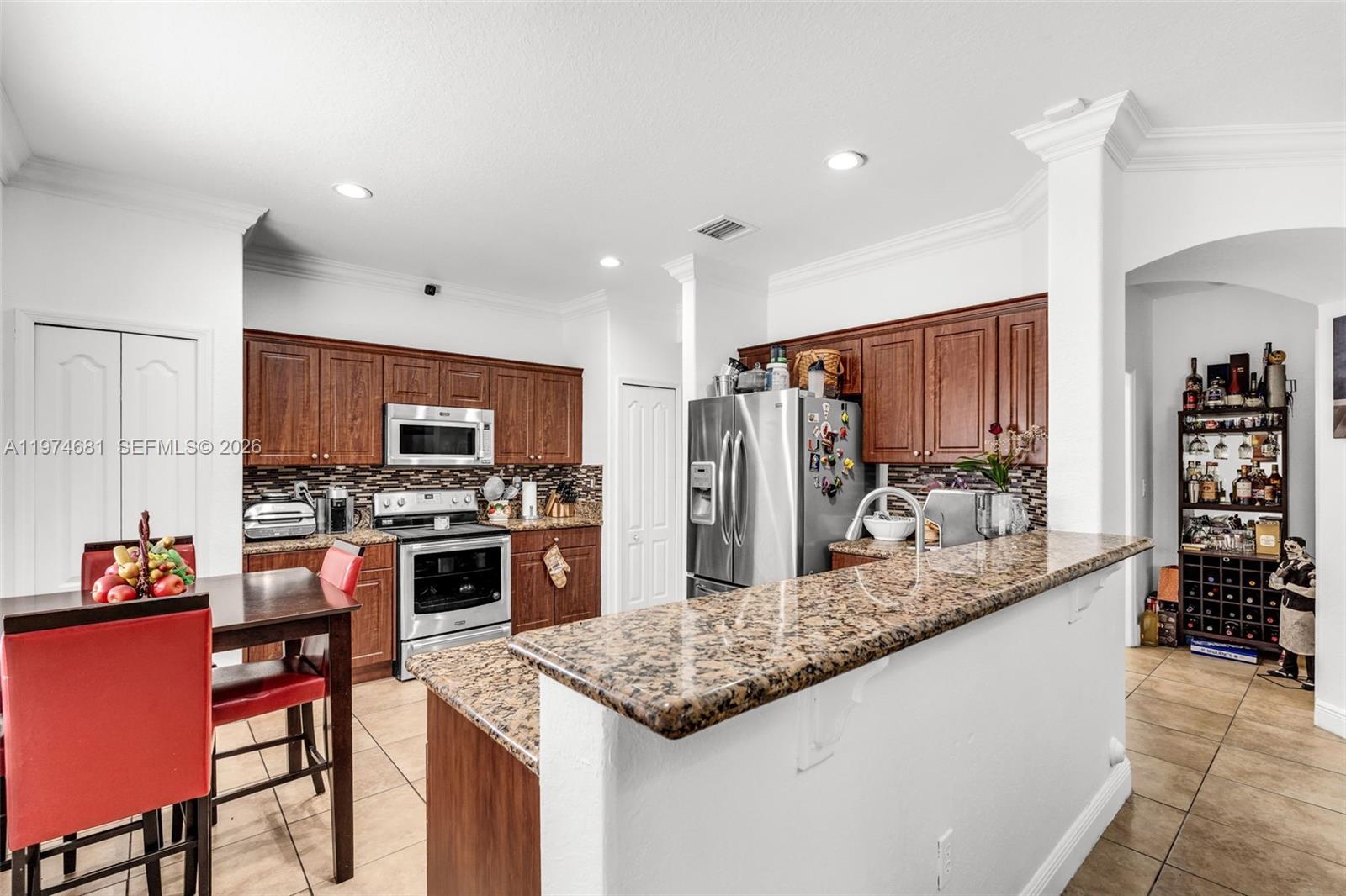 16610 Southwest 57th Lane Miami, FL 33193 - Photo 14 of 57 a kitchen with stainless steel appliances granite countertop a sink stove and refrigerator
