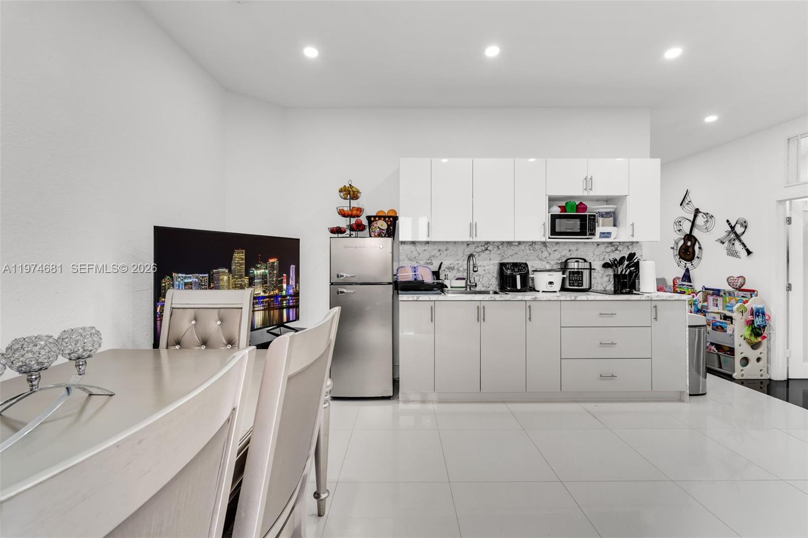 16610 Southwest 57th Lane Miami, FL 33193 - Photo 42 of 57 a kitchen with white cabinets and stainless steel appliances