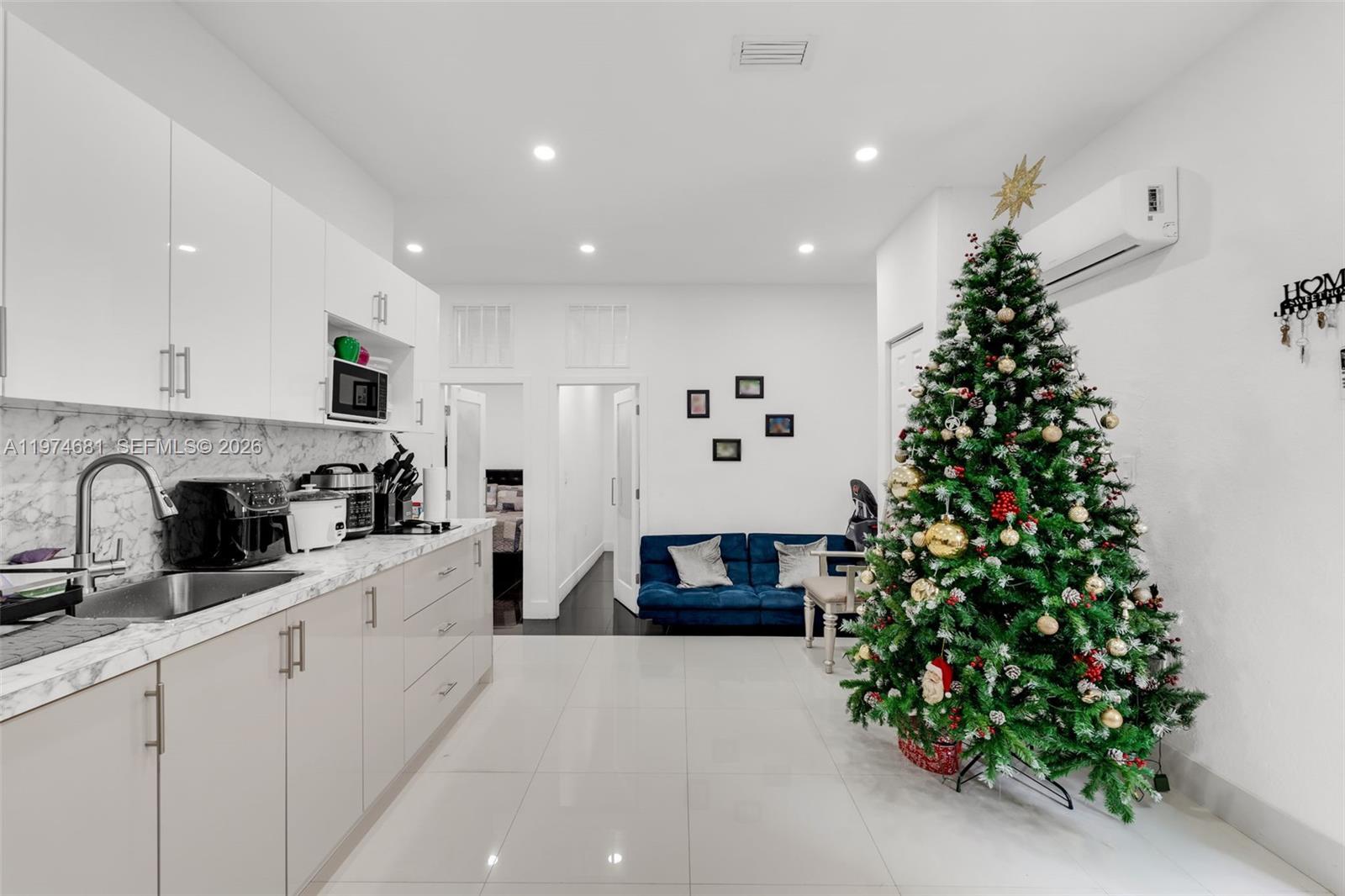 16610 Southwest 57th Lane Miami, FL 33193 - Photo 43 of 57 a large white kitchen with kitchen island white cabinets and a potted plant