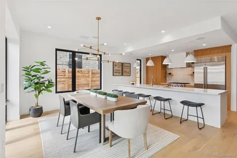 a kitchen with a table chairs stove and wooden floor