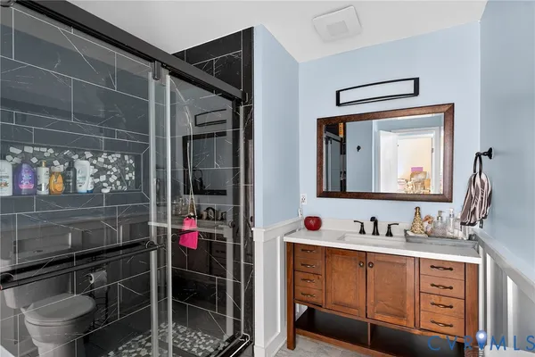 a bathroom with a sink vanity mirror and toilet