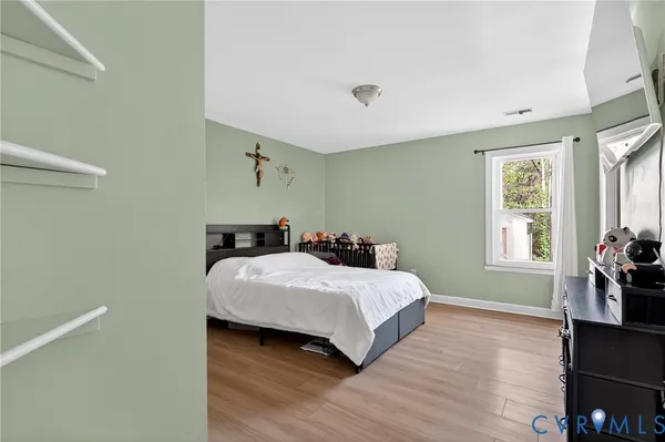 a bedroom with a bed and wooden floor