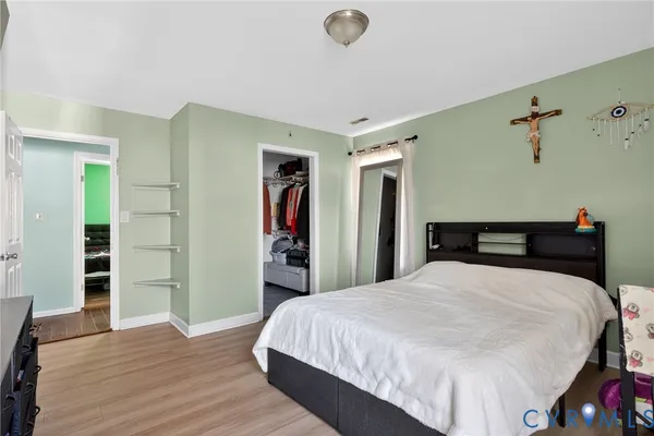 a bedroom with a bed and a wooden floor