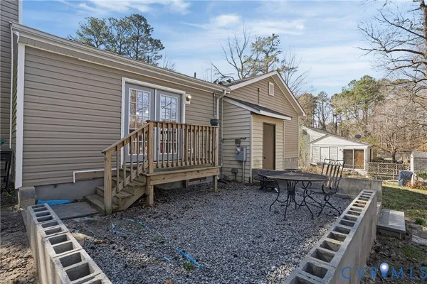 a backyard of a house with barbeque oven table and chairs