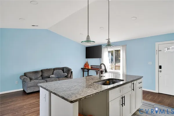 a kitchen with a sink dishwasher and a stove with wooden floor