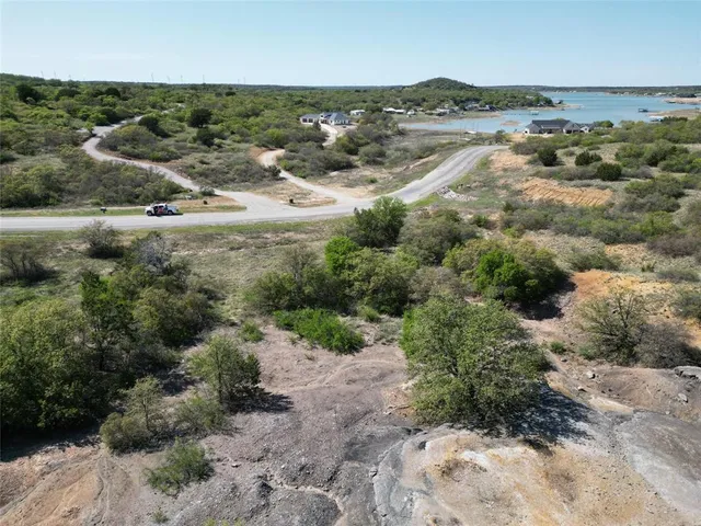 an aerial view of residential houses with outdoor space and trees