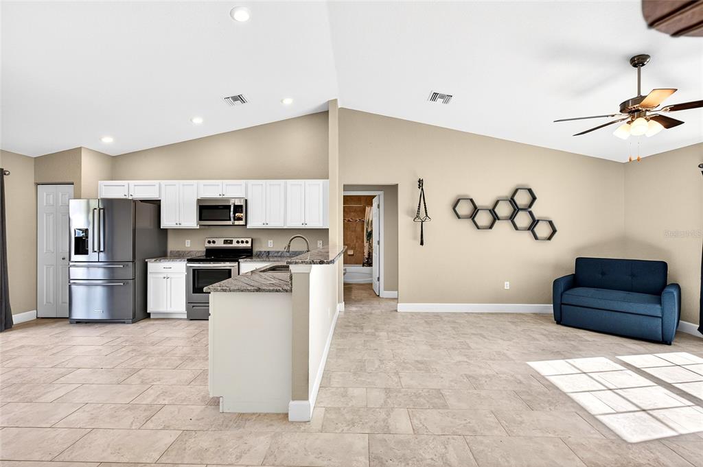 501 Marion Oaks Golf Road Ocala, FL 34473 - Photo 12 of 33 a kitchen with stainless steel appliances kitchen island granite countertop a refrigerator and a stove top oven