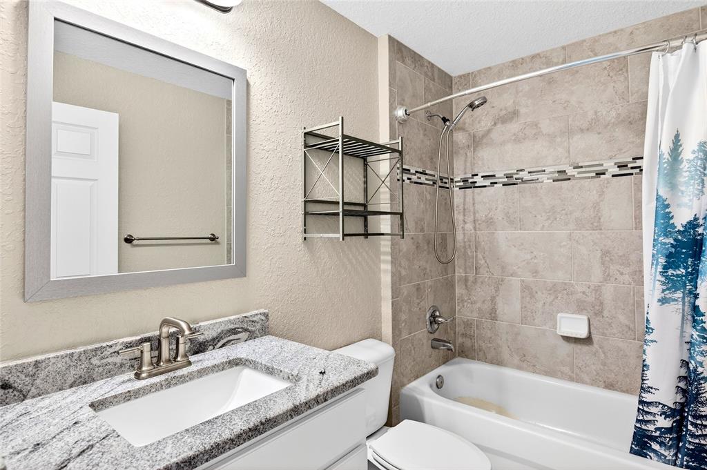 501 Marion Oaks Golf Road Ocala, FL 34473 - Photo 13 of 33 a bathroom with a granite countertop sink mirror toilet and bathtub