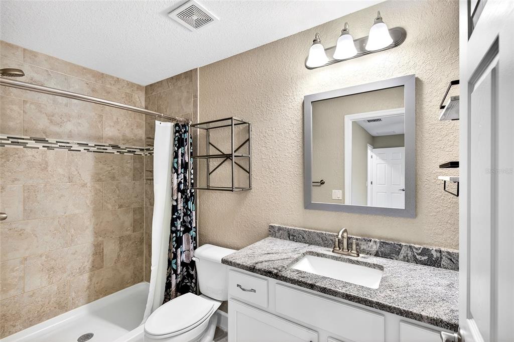 501 Marion Oaks Golf Road Ocala, FL 34473 - Photo 14 of 33 a bathroom with a granite countertop sink toilet a mirror and shower