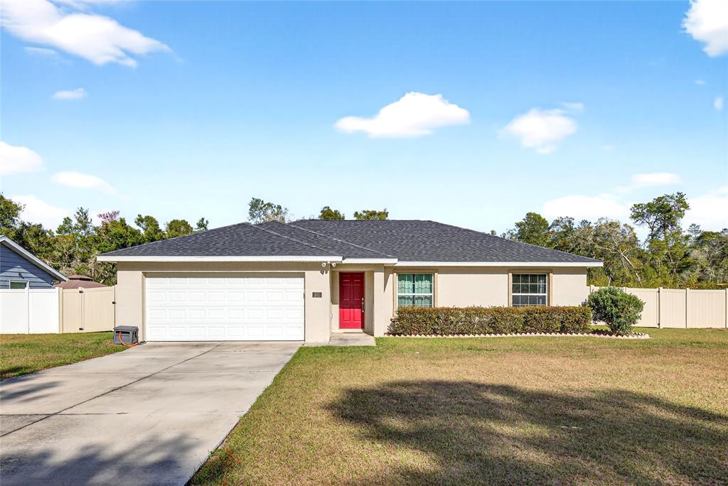 501 Marion Oaks Golf Road Ocala, FL 34473 - Photo 2 of 33 a front view of a house with a yard and garage