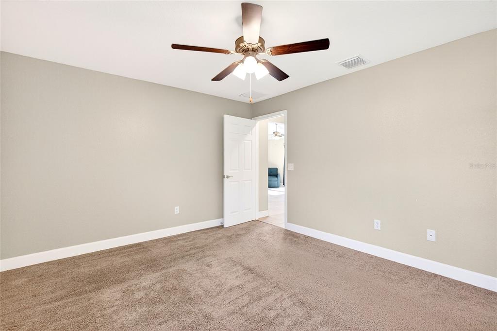 501 Marion Oaks Golf Road Ocala, FL 34473 - Photo 24 of 33 an empty room with a ceiling fan and carpet