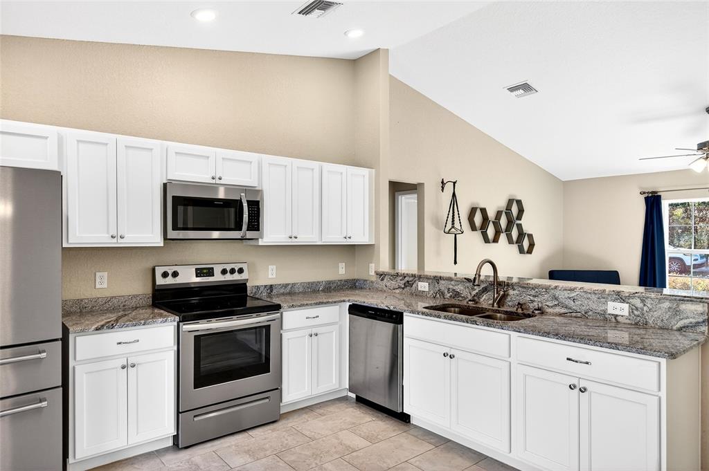 501 Marion Oaks Golf Road Ocala, FL 34473 - Photo 7 of 33 a kitchen with stainless steel appliances granite countertop white cabinets a sink and dishwasher