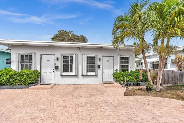 a front view of a house with a yard and potted plants