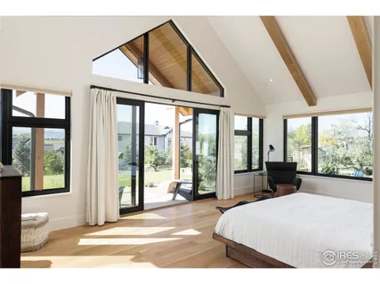 a bedroom with a bed and large windows