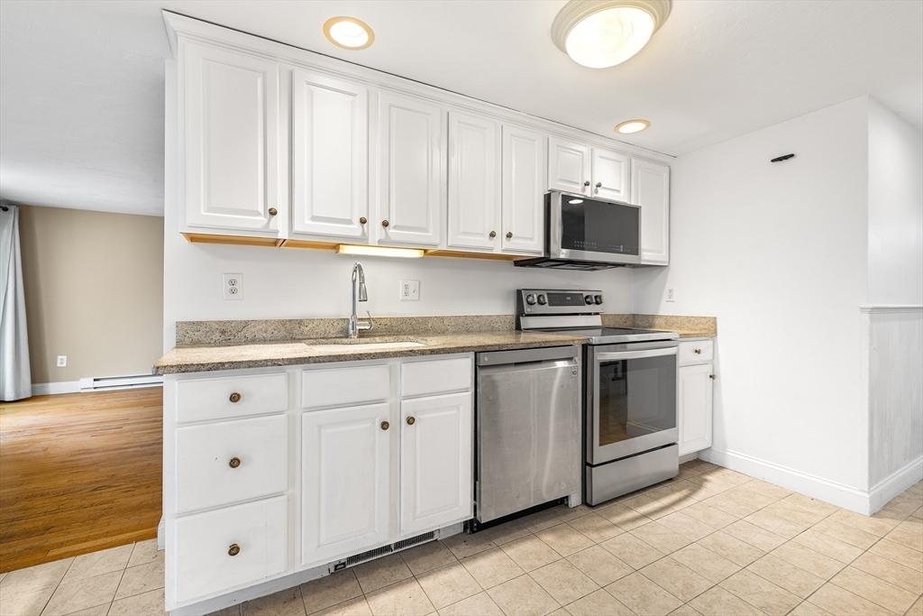544 Shore Road, Unit 3 Truro, MA 02666 - Photo 15 of 30 a kitchen with granite countertop white cabinets and stainless steel appliances