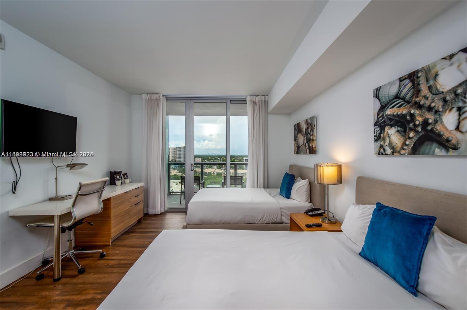 2602 East Hallandale Beach Boulevard, Unit R1606 Hallandale Beach, FL 33009 - Photo 8 of 21 a room with a bed and a flat screen tv